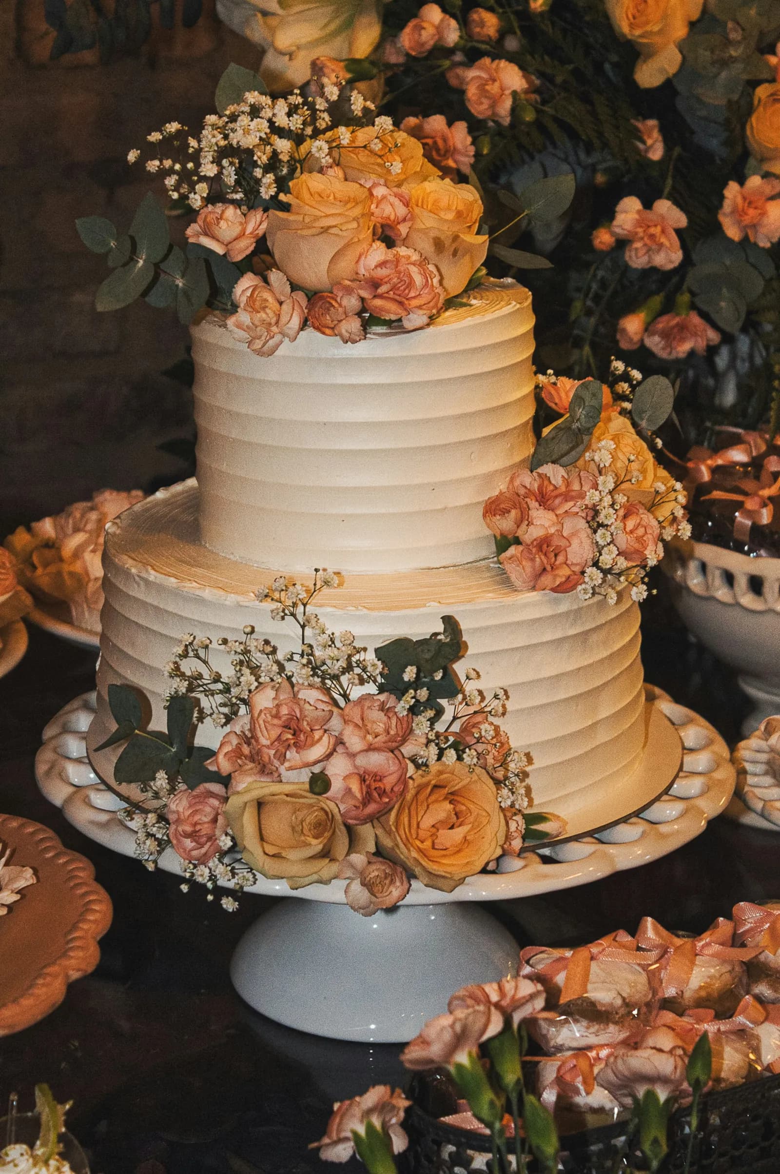 Bolo de casamento de dois andares decorado com flores cor de pêssego
