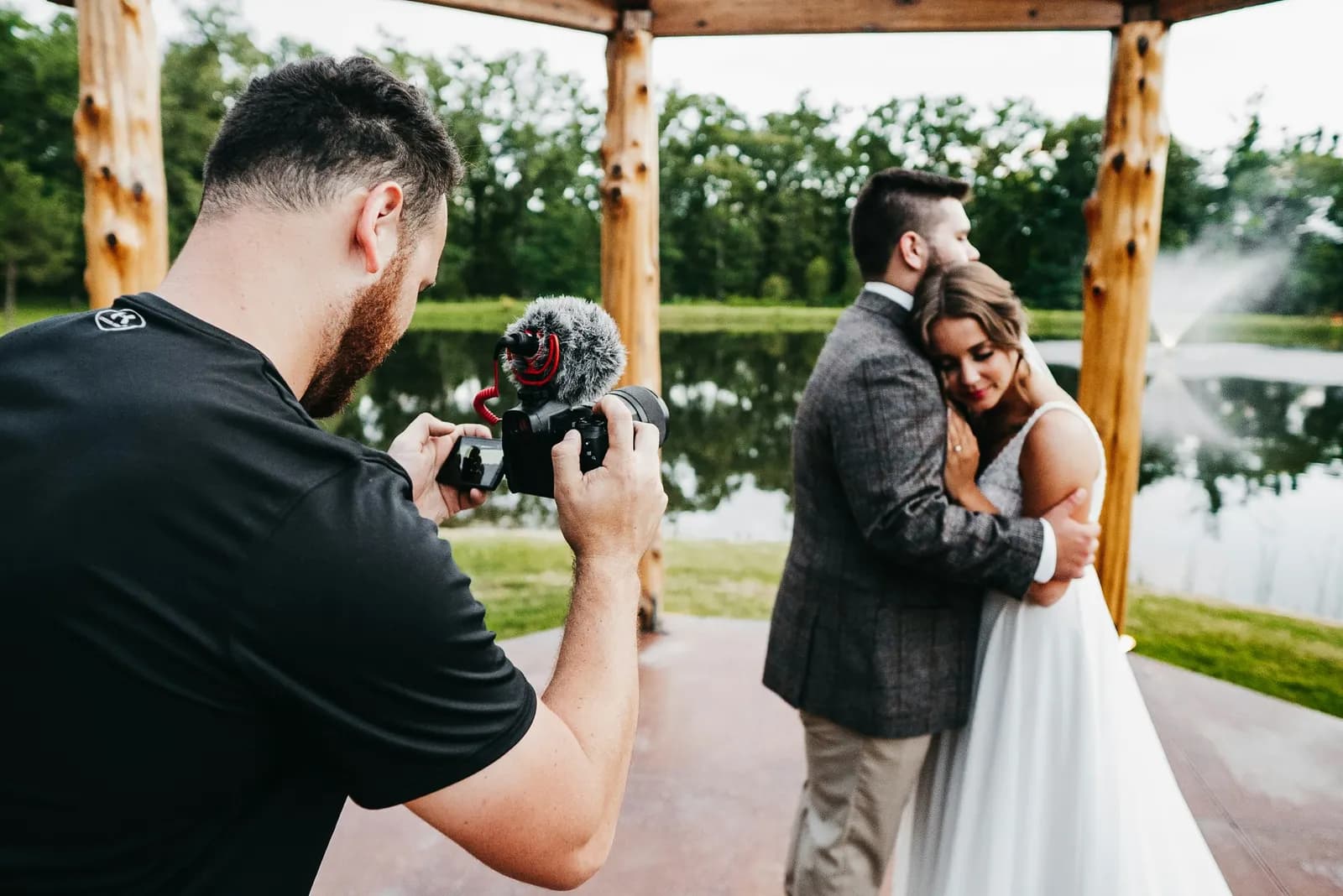 Fotógrafo filma o casal abraçado em um caramanchão de madeira
